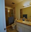 A clean bathroom with a glass shower, toilet, and sink.